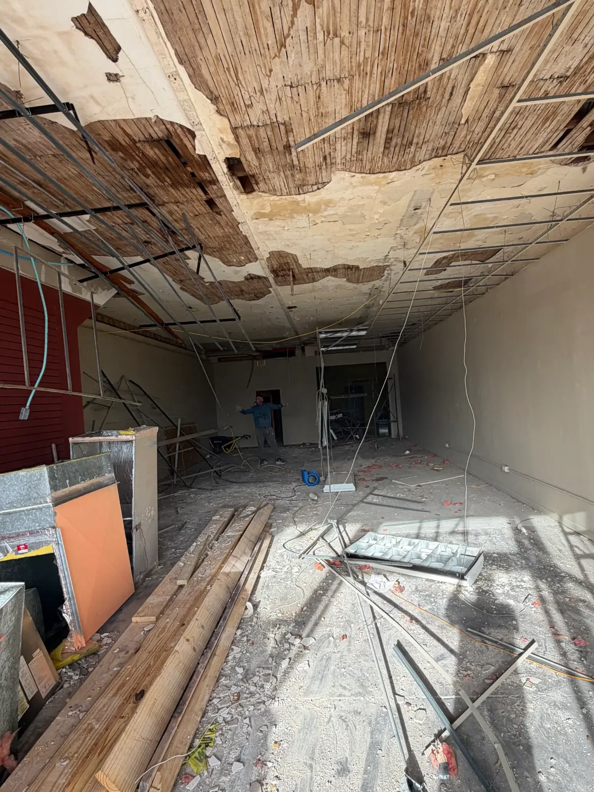 Commercial ceiling tear-out in progress inside a storefront build-out